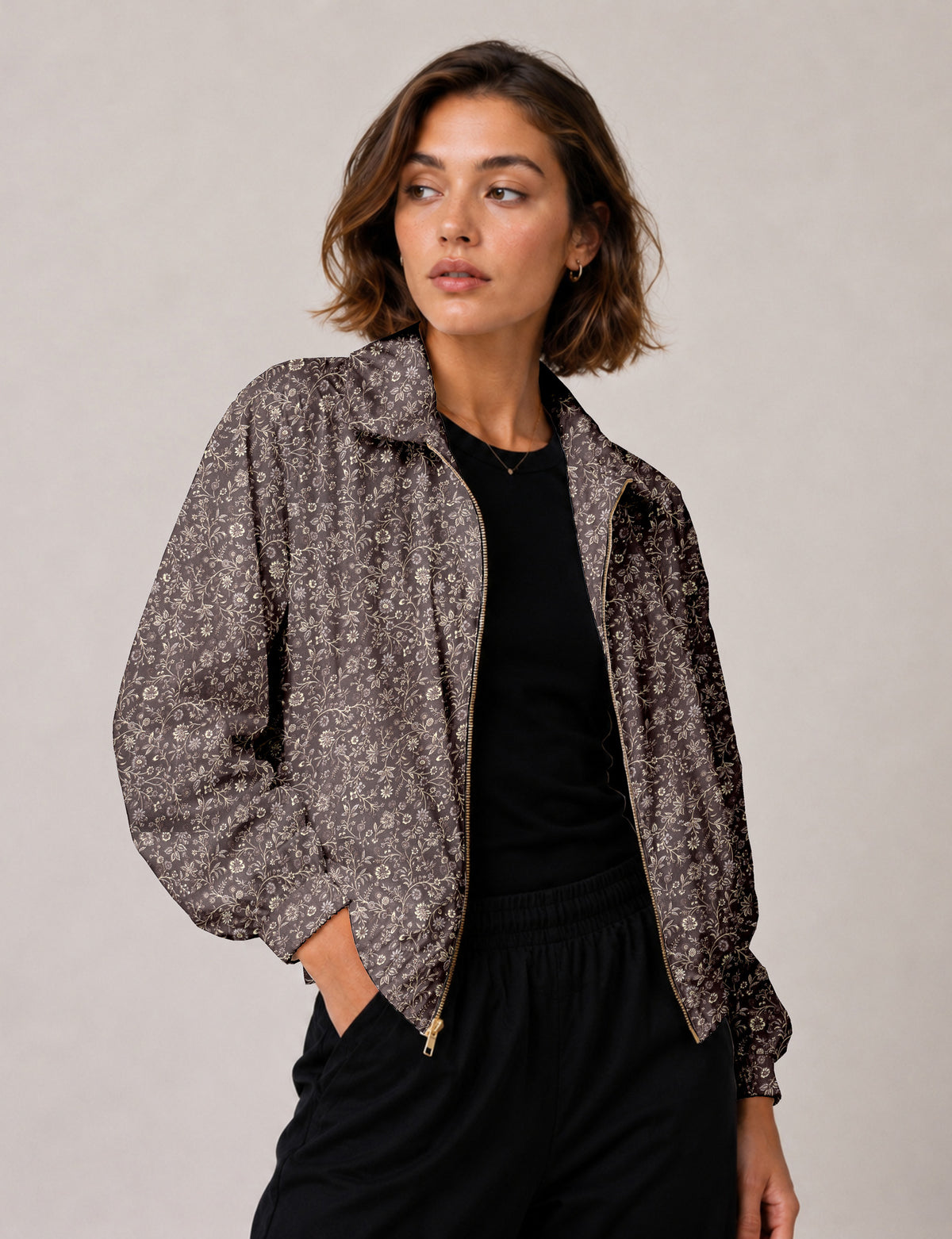Woman wearing a yellow floral bomber jacket with front zipper, elastic cuffs, and side pockets, shown from front view