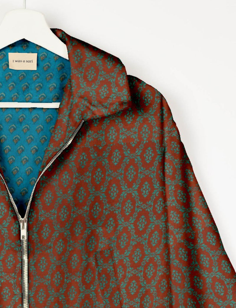 Brown bomber jacket with teal Indian ethnic pattern, silver zipper, and blue patterned inner lining labeled "I was a sari"