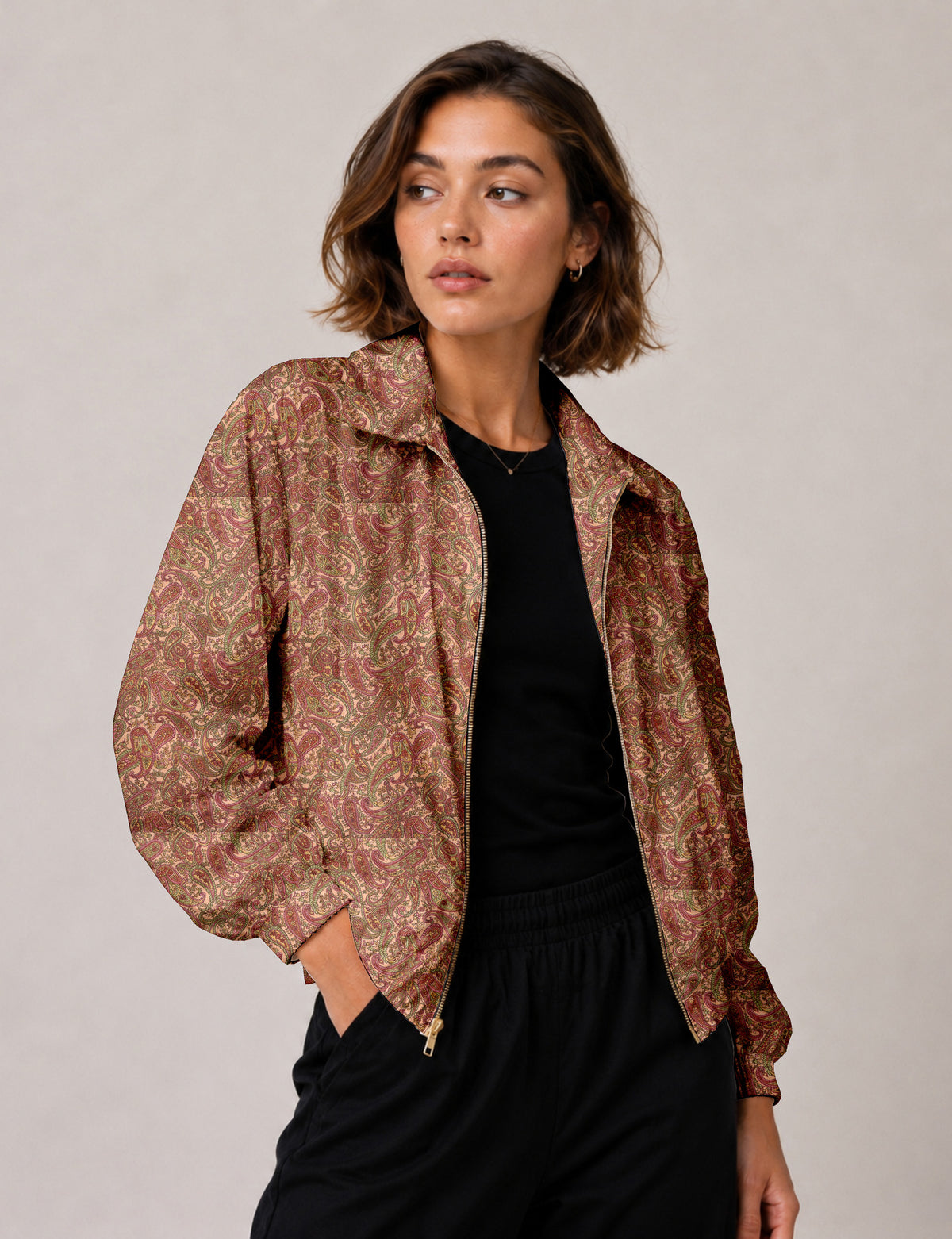 Woman wearing a yellow floral bomber jacket with front zipper, elastic cuffs, and side pockets, shown from front view