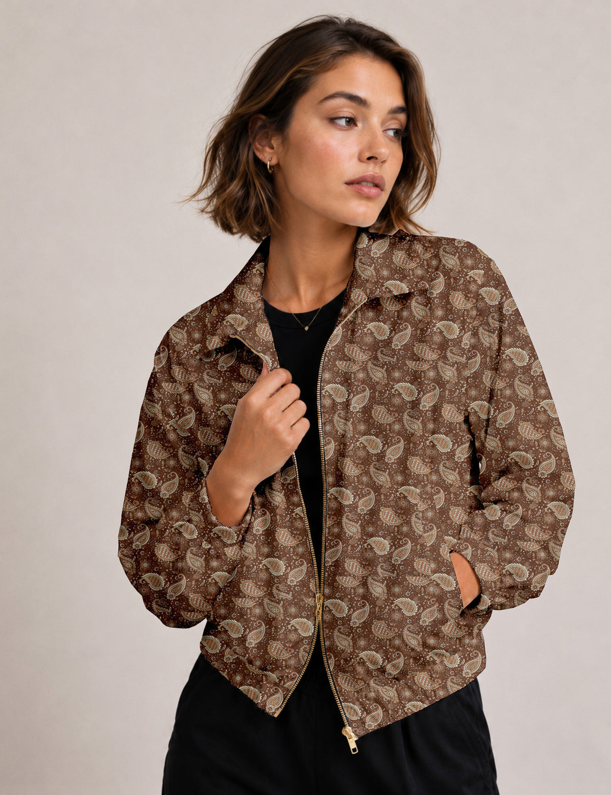 Brown floral bomber jacket with front zipper, elastic cuffs and hem, hanging on white hanger, red floral inner lining visible