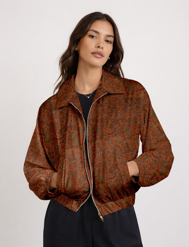 Woman wearing a yellow floral bomber jacket with front zipper, elastic cuffs, and side pockets, shown from front view