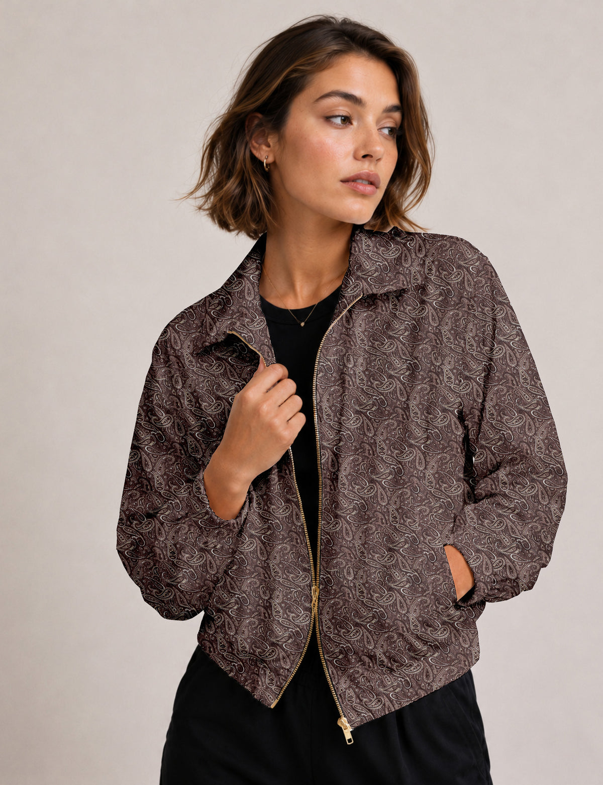 Brown floral bomber jacket with front zipper, elastic cuffs and hem, hanging on white hanger, red floral inner lining visible