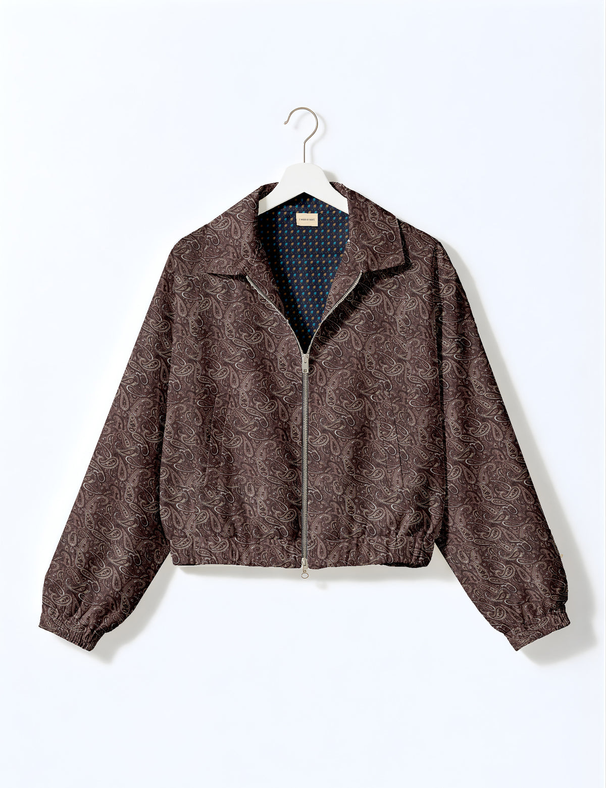 Brown floral bomber jacket with front zipper, elastic cuffs and hem, hanging on white hanger, red floral inner lining visible