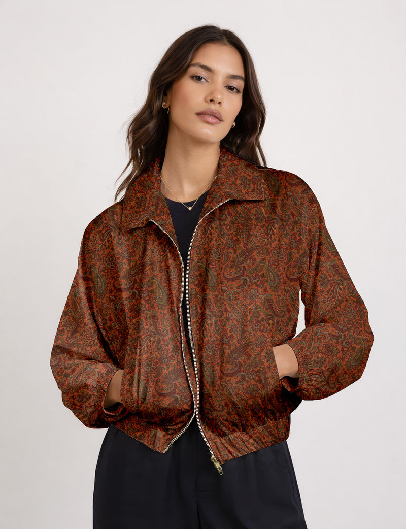 Woman wearing a yellow floral bomber jacket with front zipper, elastic cuffs, and side pockets, shown from front view