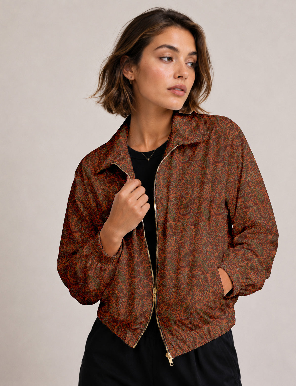 Brown floral bomber jacket with front zipper, elastic cuffs and hem, hanging on white hanger, red floral inner lining visible