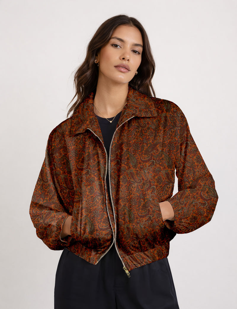 Woman wearing a yellow floral bomber jacket with front zipper, elastic cuffs, and side pockets, shown from front view