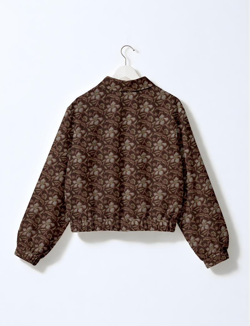 Brown bomber jacket with tropical floral pattern, elastic cuffs and waistband, shown from back on white hanger