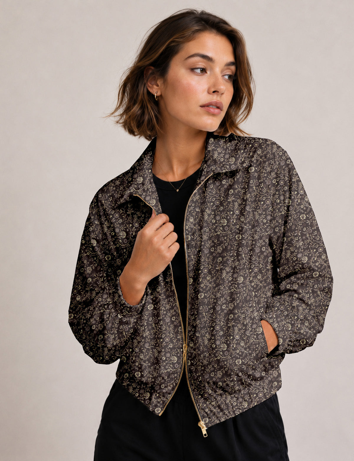 Woman wearing a yellow floral bomber jacket with front zipper, elastic cuffs, and side pockets, shown from front view
