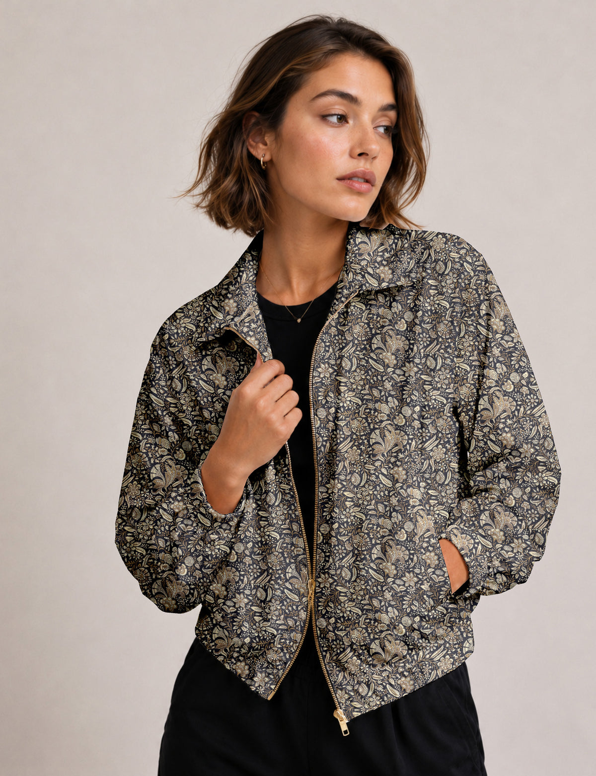 Woman wearing a yellow floral bomber jacket with front zipper, elastic cuffs, and side pockets, shown from front view