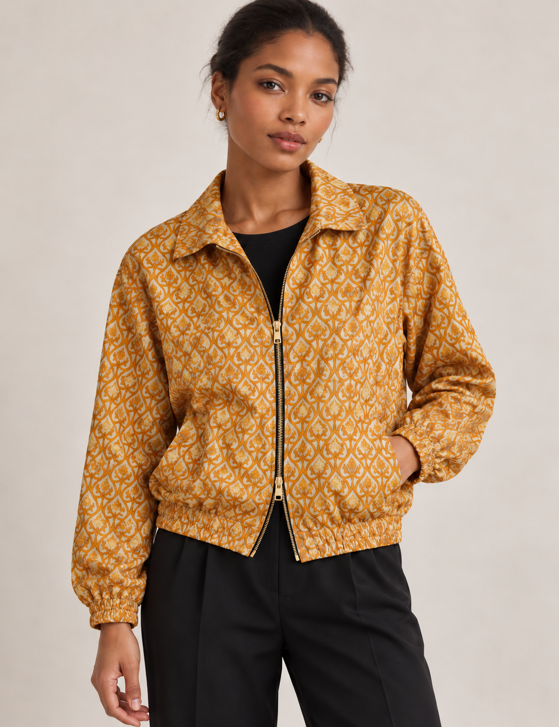 Woman wearing a yellow floral bomber jacket with front zipper, elastic cuffs, and side pockets, shown from front view