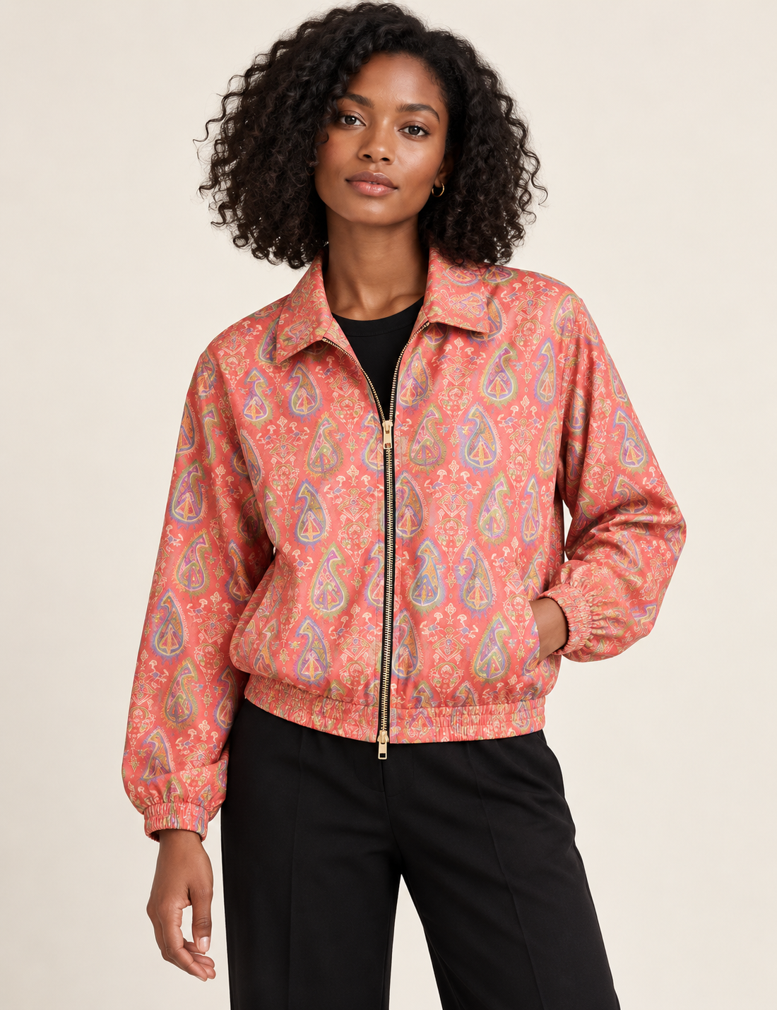 Woman wearing a yellow floral bomber jacket with front zipper, elastic cuffs, and side pockets, shown from front view