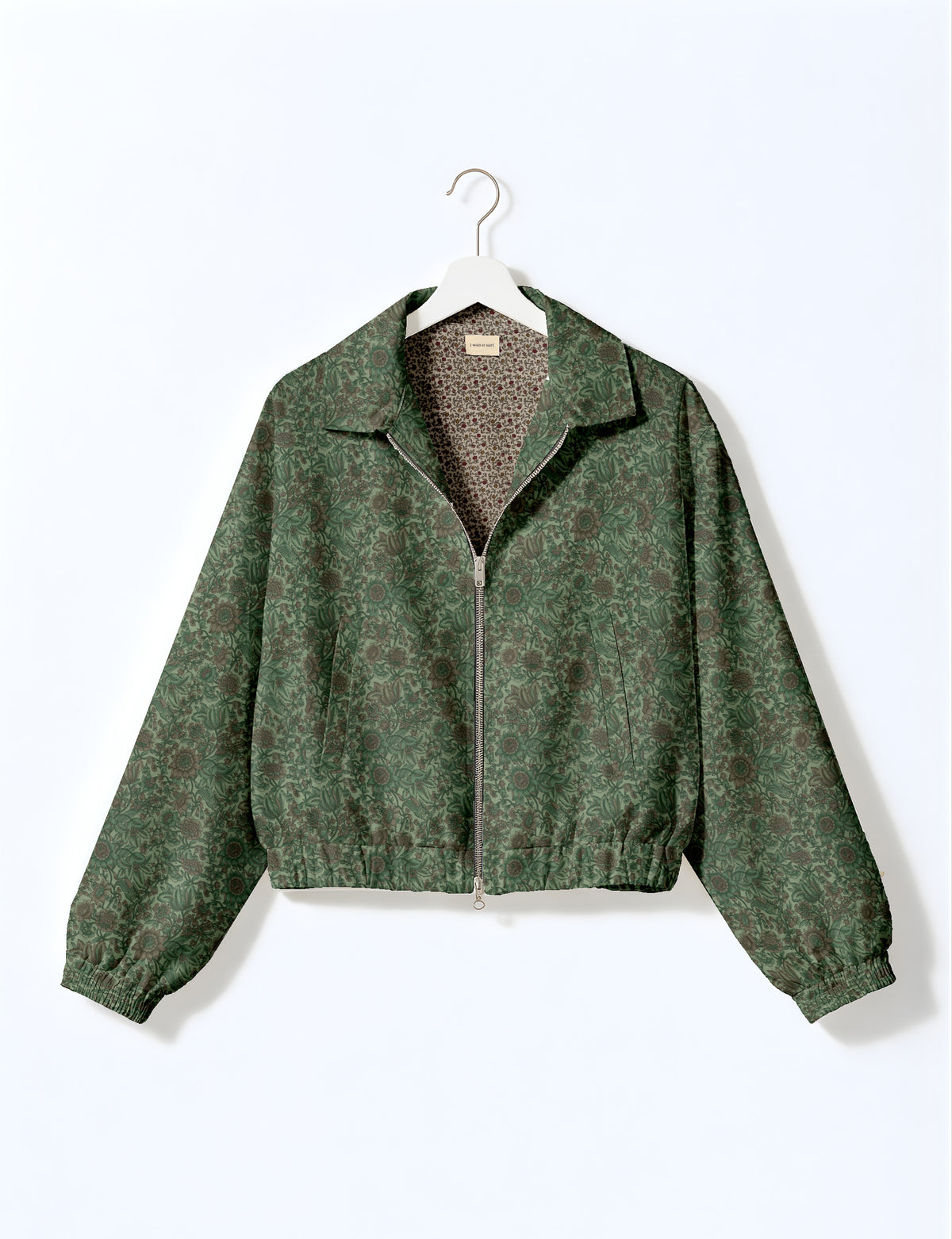 Brown floral bomber jacket with front zipper, elastic cuffs and hem, hanging on white hanger, red floral inner lining visible