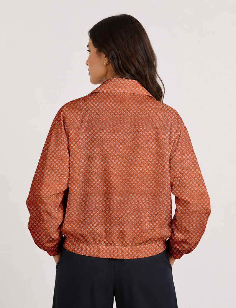 Brown floral bomber jacket with front zipper, elastic cuffs and hem, hanging on white hanger, red floral inner lining visible