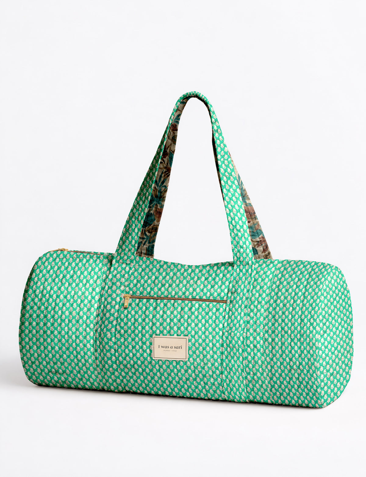 Brown paisley quilted bowling bag with front zipper pocket, held by person wearing white shirt and light blue jeans