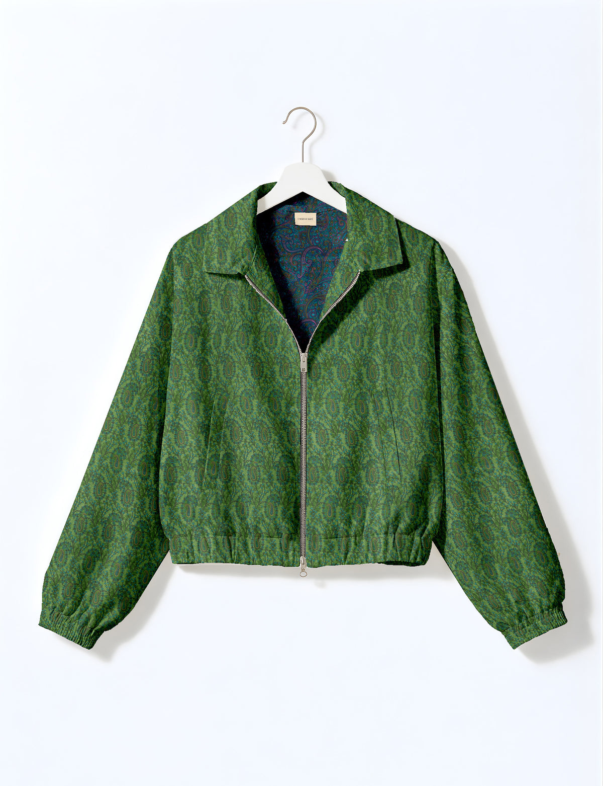 Brown floral bomber jacket with front zipper, elastic cuffs and hem, hanging on white hanger, red floral inner lining visible
