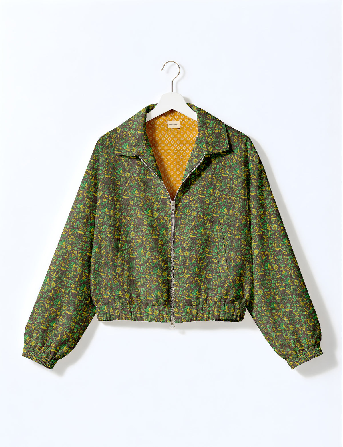 Woman wearing a yellow floral bomber jacket with front zipper, elastic cuffs, and side pockets, shown from front view