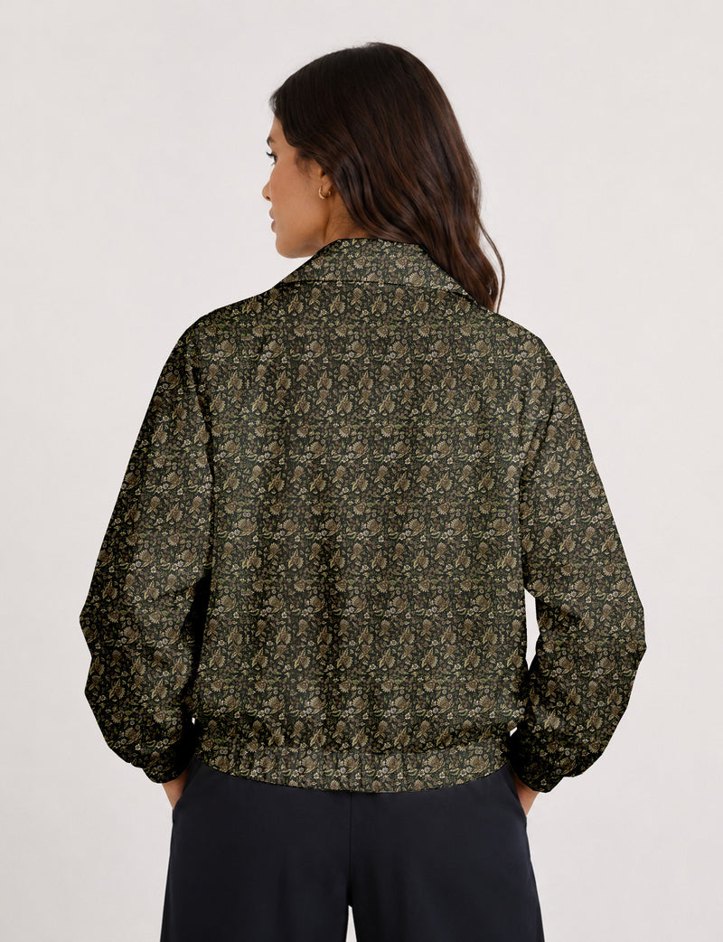 Woman wearing a yellow floral bomber jacket with front zipper, elastic cuffs, and side pockets, shown from front view
