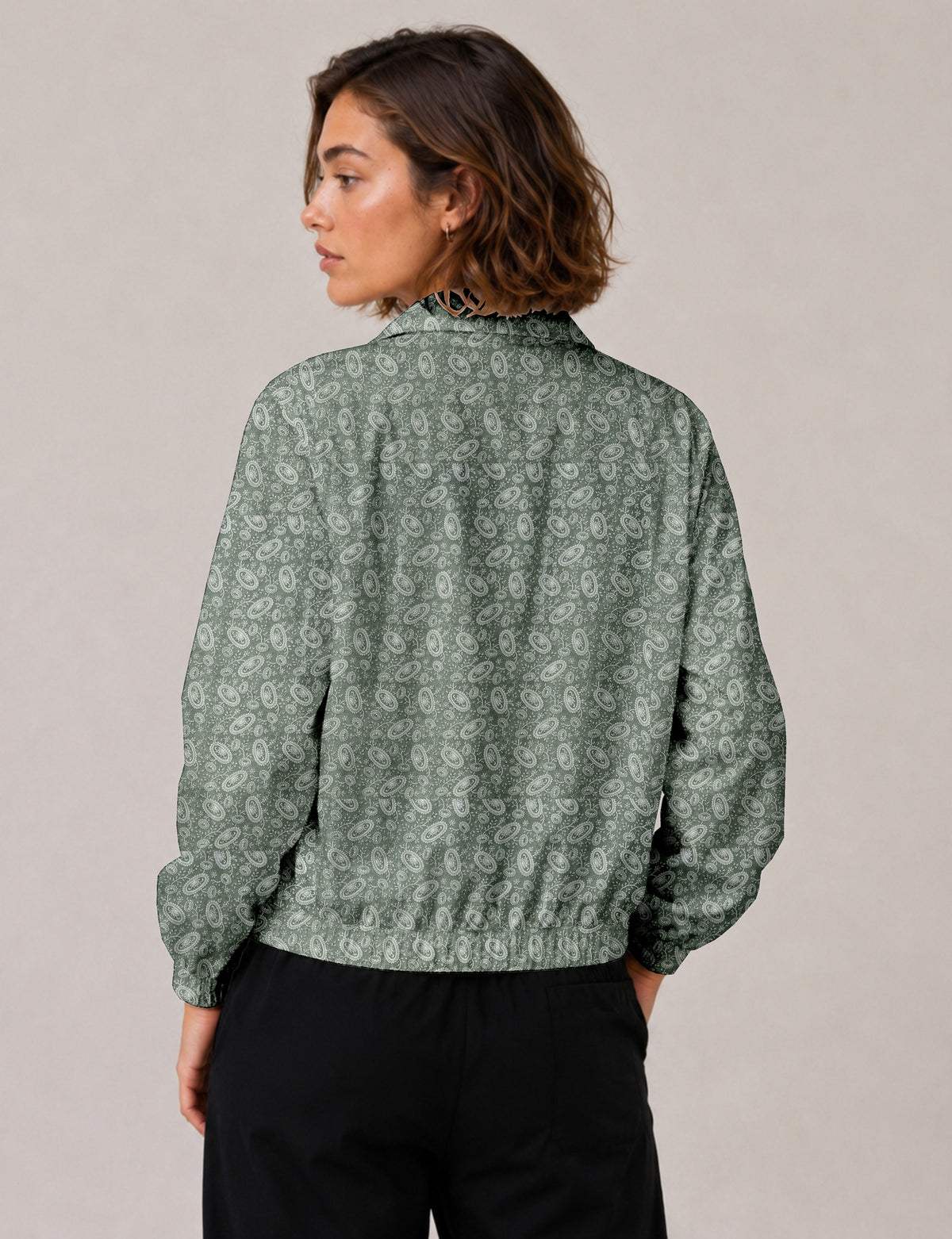 Woman wearing a yellow floral bomber jacket with front zipper, elastic cuffs, and side pockets, shown from front view