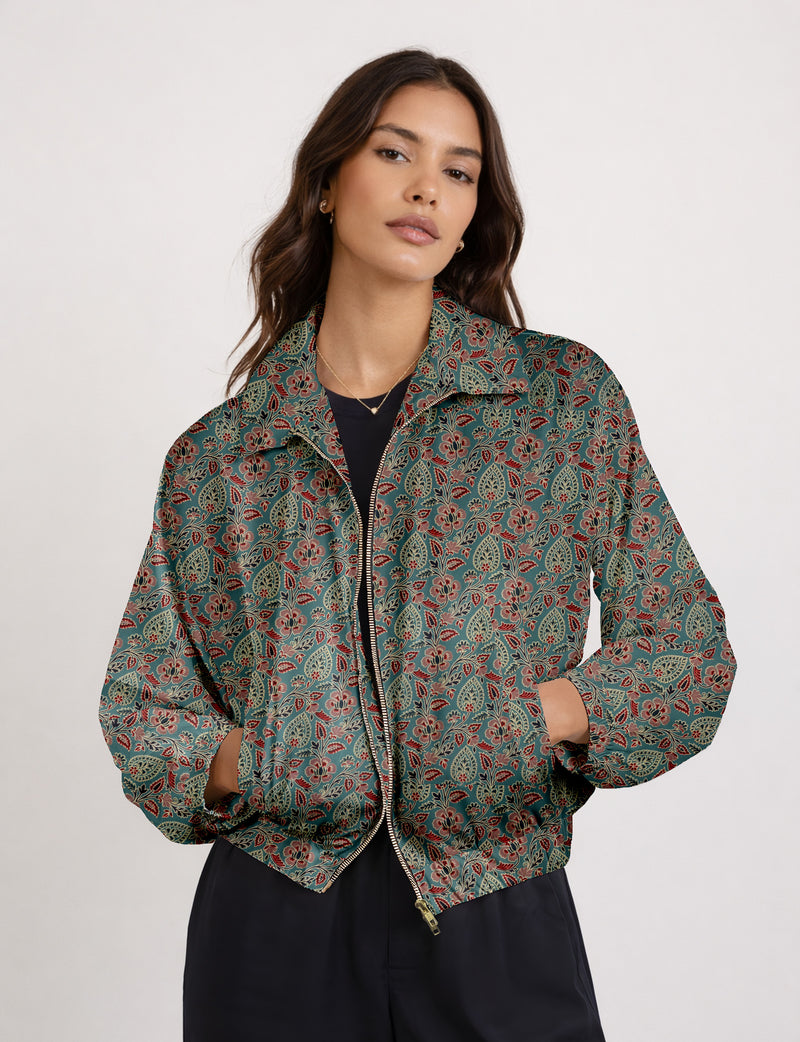 Woman wearing a yellow floral bomber jacket with front zipper, elastic cuffs, and side pockets, shown from front view
