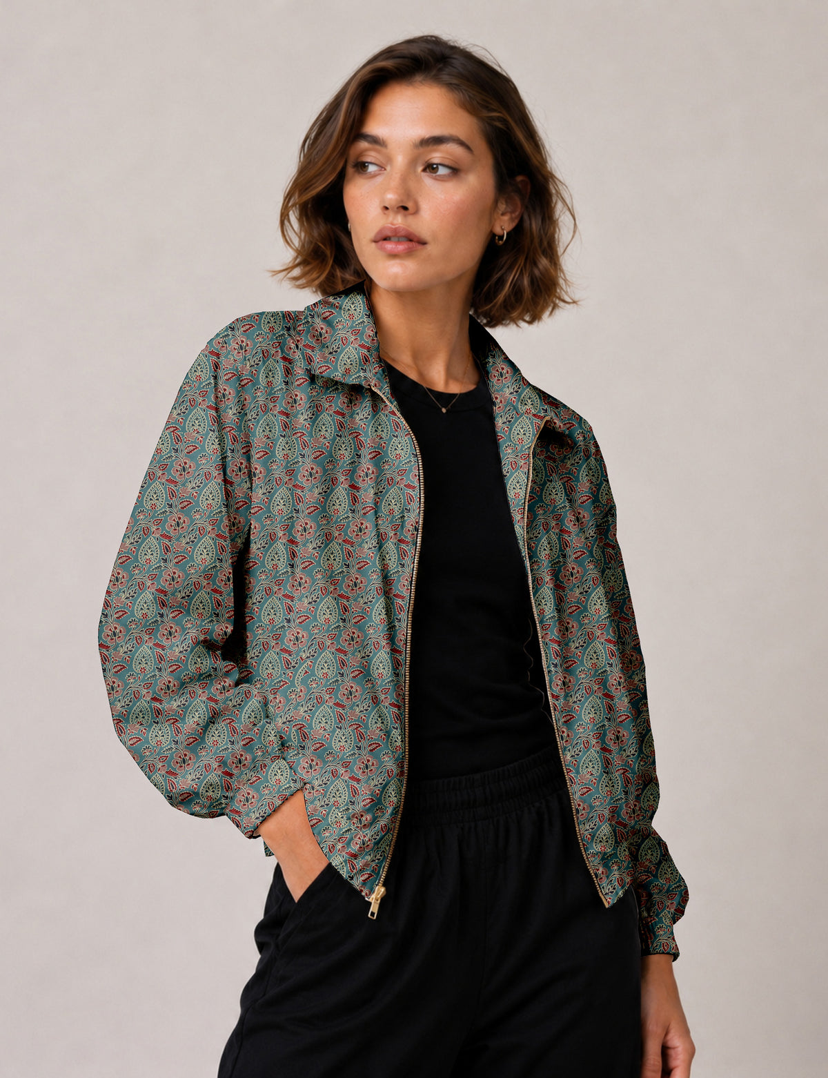 Woman wearing a yellow floral bomber jacket with front zipper, elastic cuffs, and side pockets, shown from front view