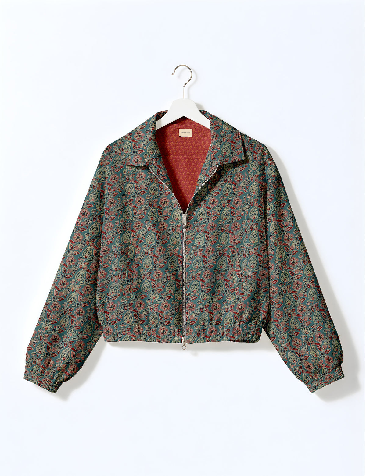 Brown floral bomber jacket with front zipper, elastic cuffs and hem, hanging on white hanger, red floral inner lining visible