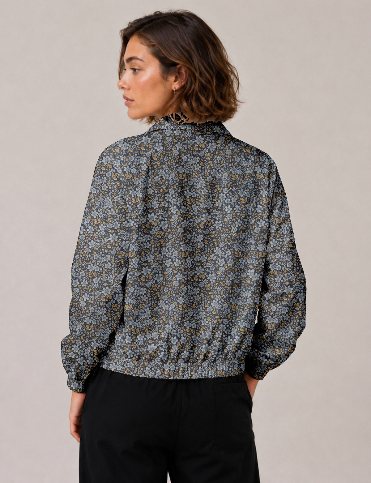 Brown floral bomber jacket with front zipper, elastic cuffs and hem, hanging on white hanger, red floral inner lining visible