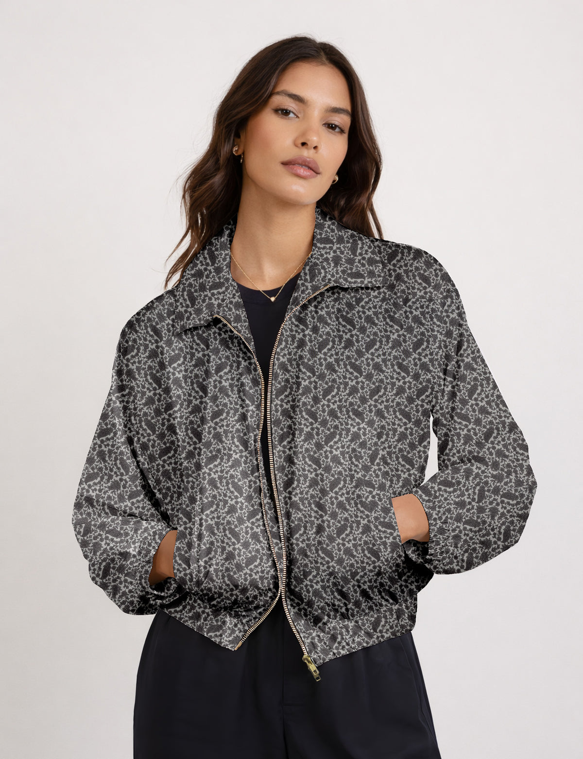 Woman wearing a yellow floral bomber jacket with front zipper, elastic cuffs, and side pockets, shown from front view