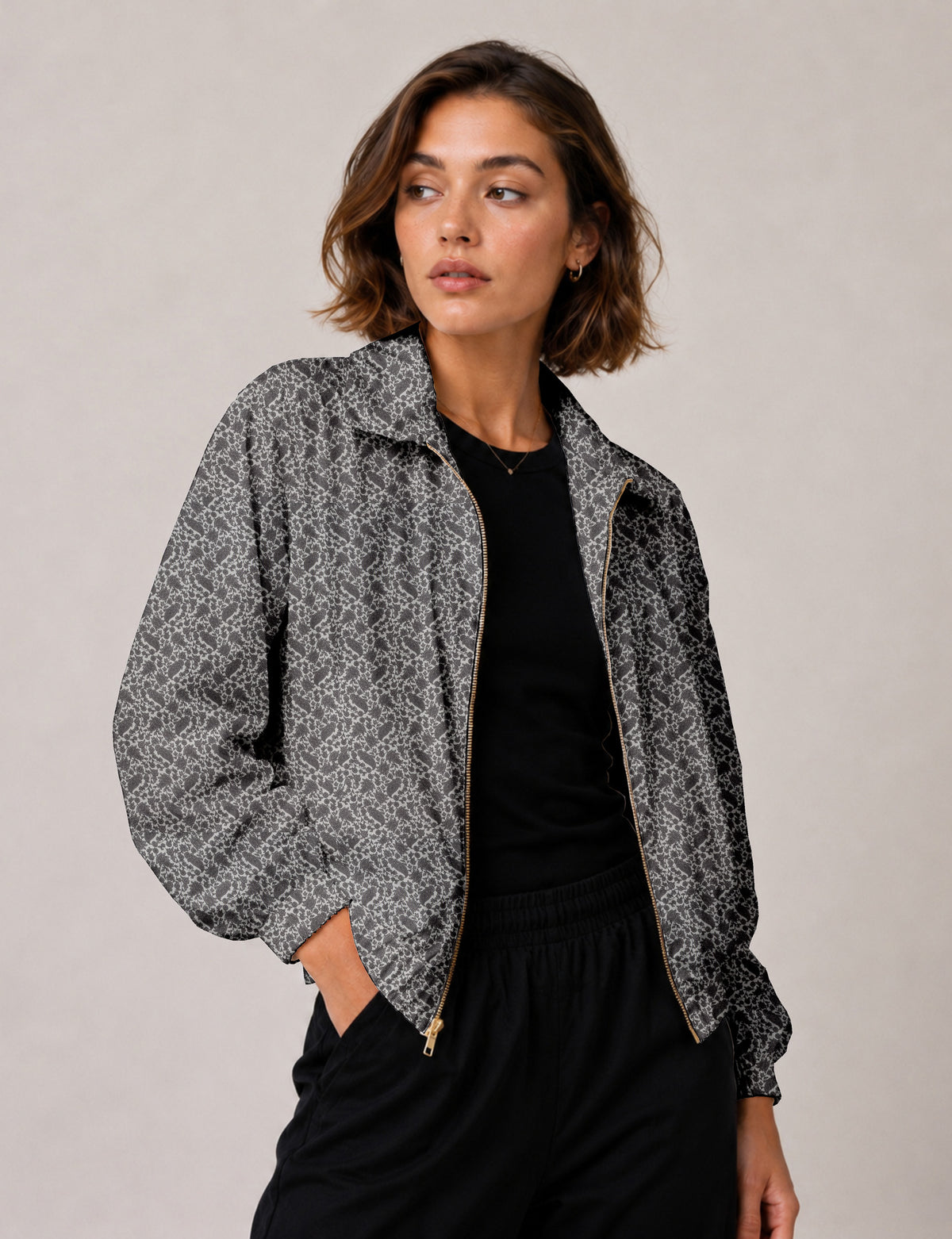 Brown floral bomber jacket with front zipper, elastic cuffs and hem, hanging on white hanger, red floral inner lining visible