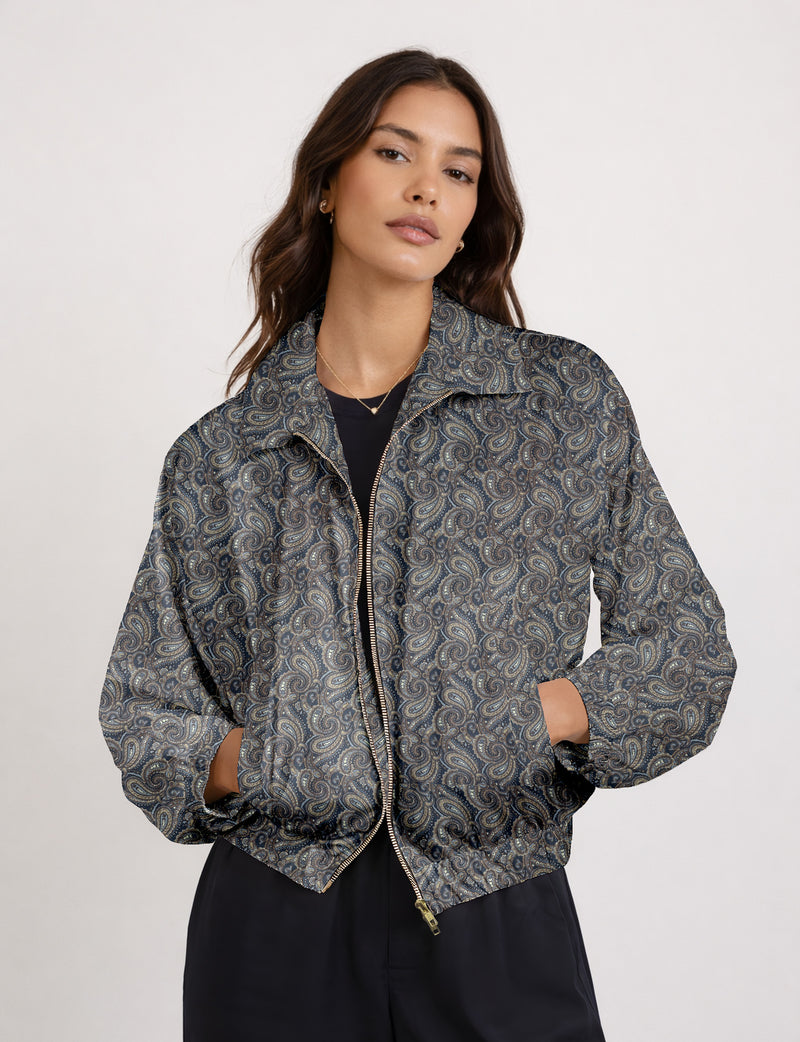 Woman wearing a yellow floral bomber jacket with front zipper, elastic cuffs, and side pockets, shown from front view