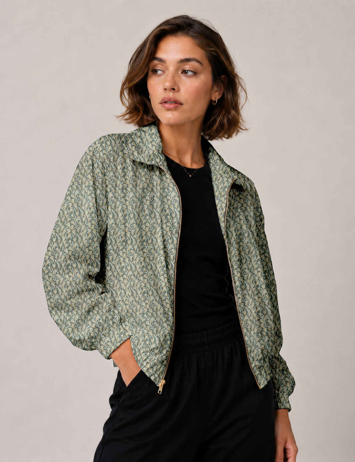 Woman wearing a yellow floral bomber jacket with front zipper, elastic cuffs, and side pockets, shown from front view