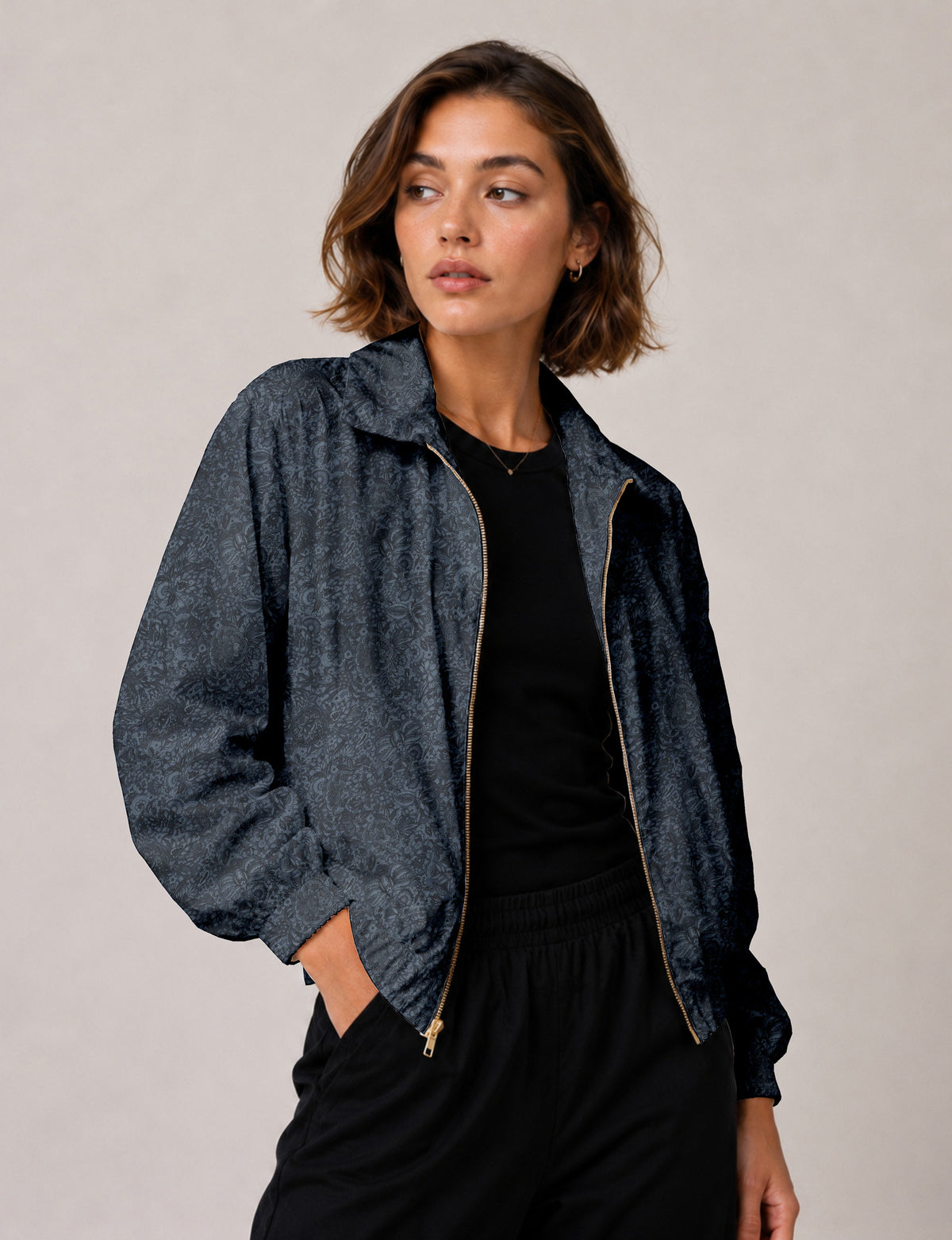 Brown floral bomber jacket with front zipper, elastic cuffs and hem, hanging on white hanger, red floral inner lining visible