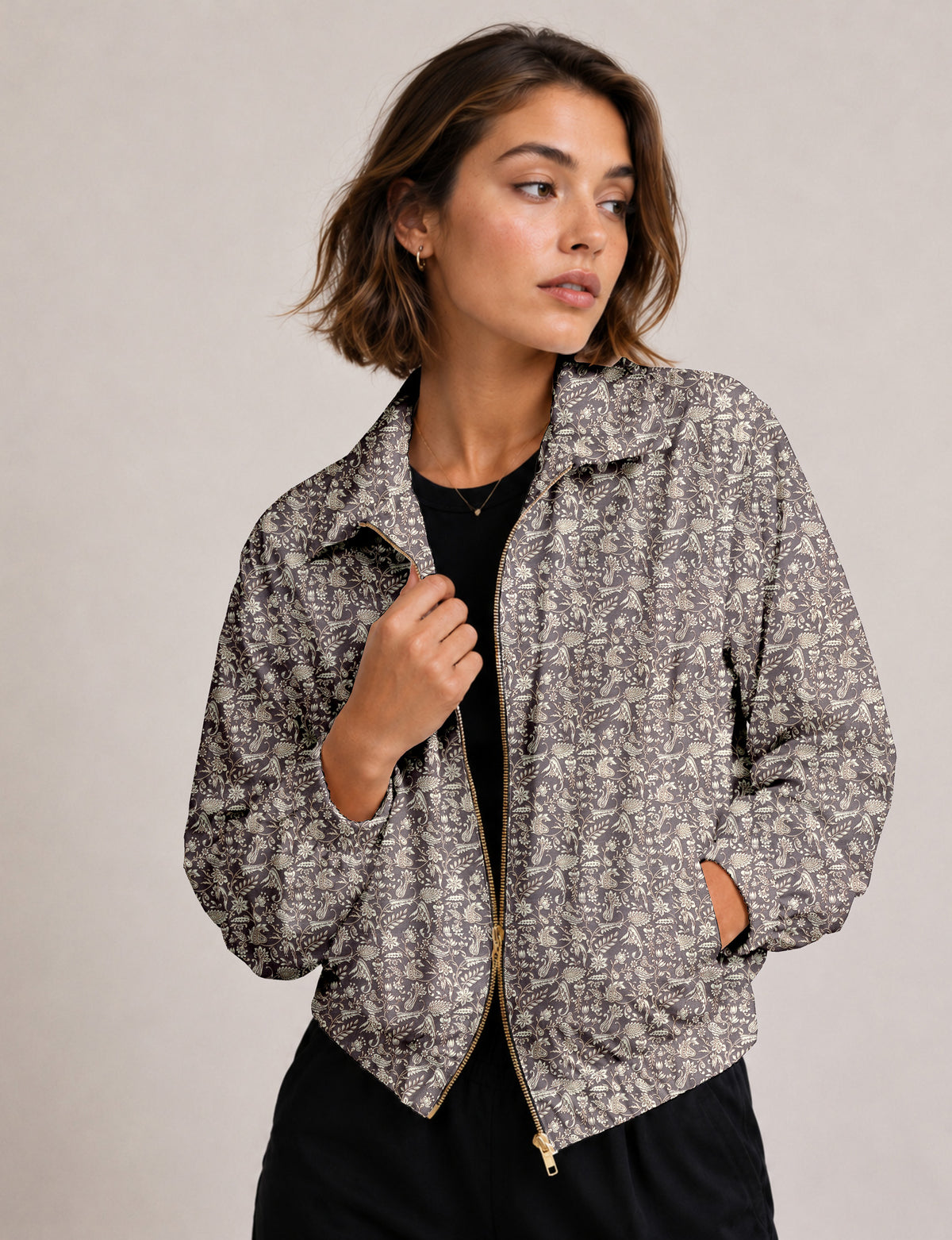 Woman wearing a yellow floral bomber jacket with front zipper, elastic cuffs, and side pockets, shown from front view