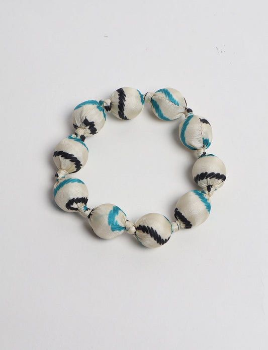 Eco friendly beaded knotted bracelet crafted from upcycled women’s clothing and repurposed sari fabrics, showcasing circular fashion and sustainable apparel.