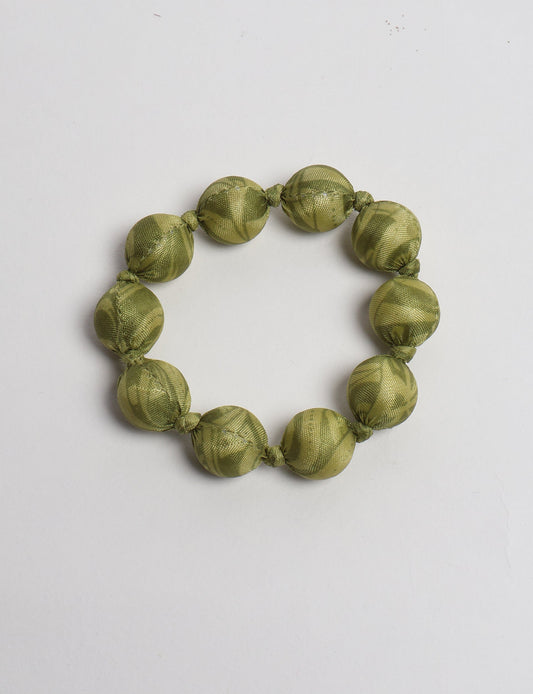 Eco friendly beaded knotted bracelet crafted from upcycled women’s clothing and repurposed sari fabrics, showcasing circular fashion and sustainable apparel.