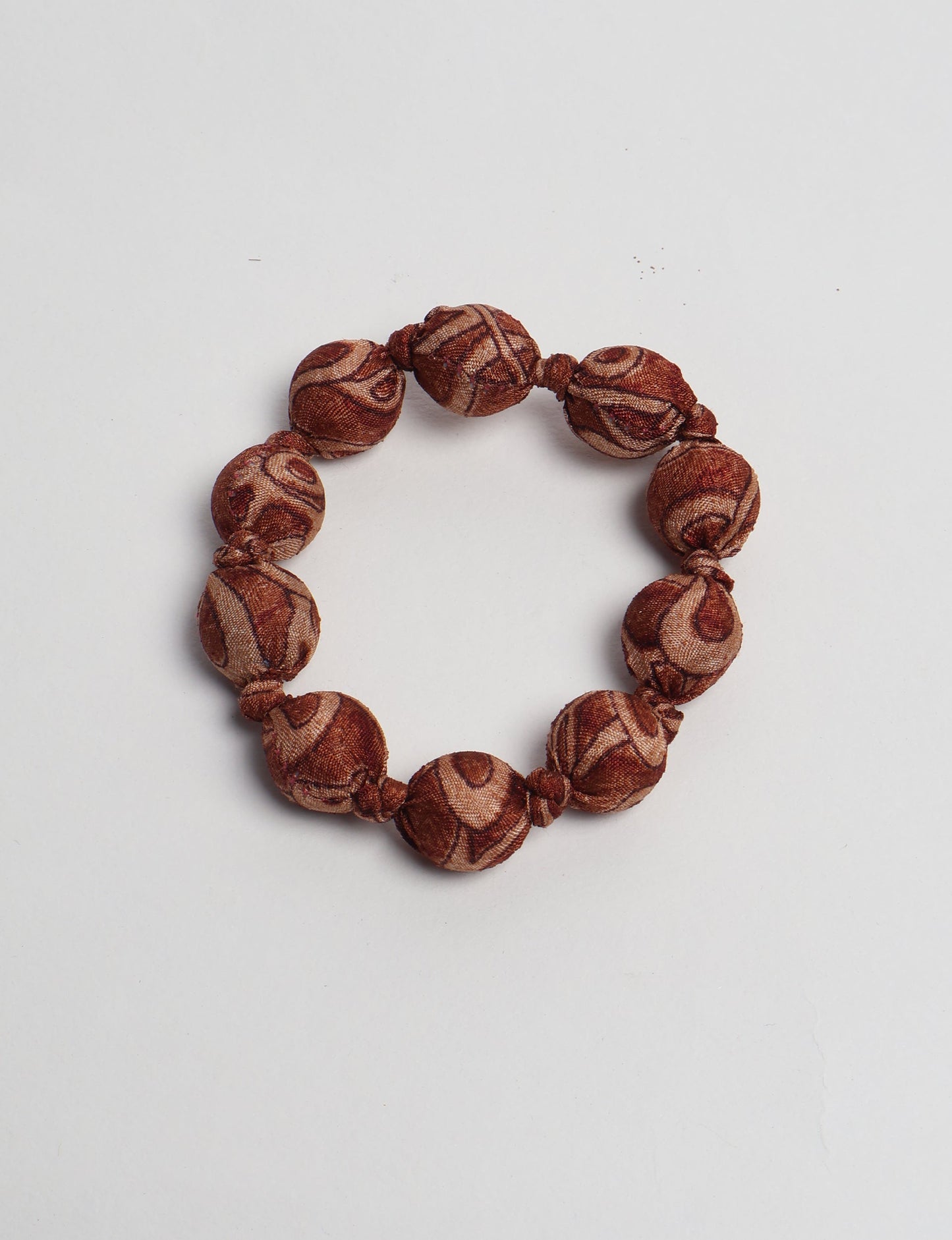 Eco friendly beaded knotted bracelet crafted from upcycled women’s clothing and repurposed sari fabrics, showcasing circular fashion and sustainable apparel.