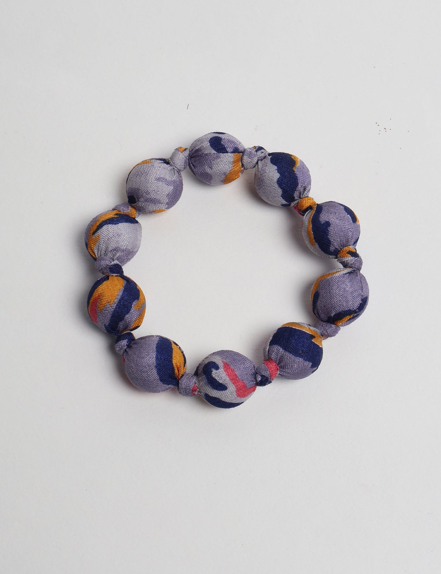 Eco friendly beaded knotted bracelet crafted from upcycled women’s clothing and repurposed sari fabrics, showcasing circular fashion and sustainable apparel.