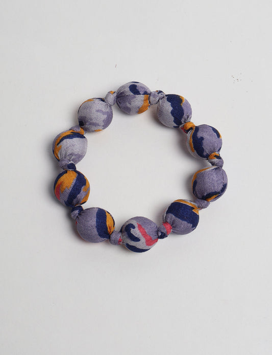 Eco friendly beaded knotted bracelet crafted from upcycled women’s clothing and repurposed sari fabrics, showcasing circular fashion and sustainable apparel.