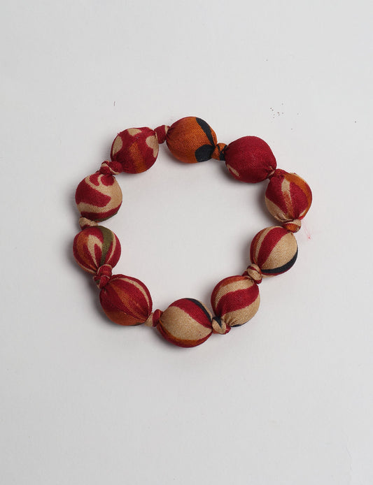 Eco friendly beaded knotted bracelet crafted from upcycled women’s clothing and repurposed sari fabrics, showcasing circular fashion and sustainable apparel.