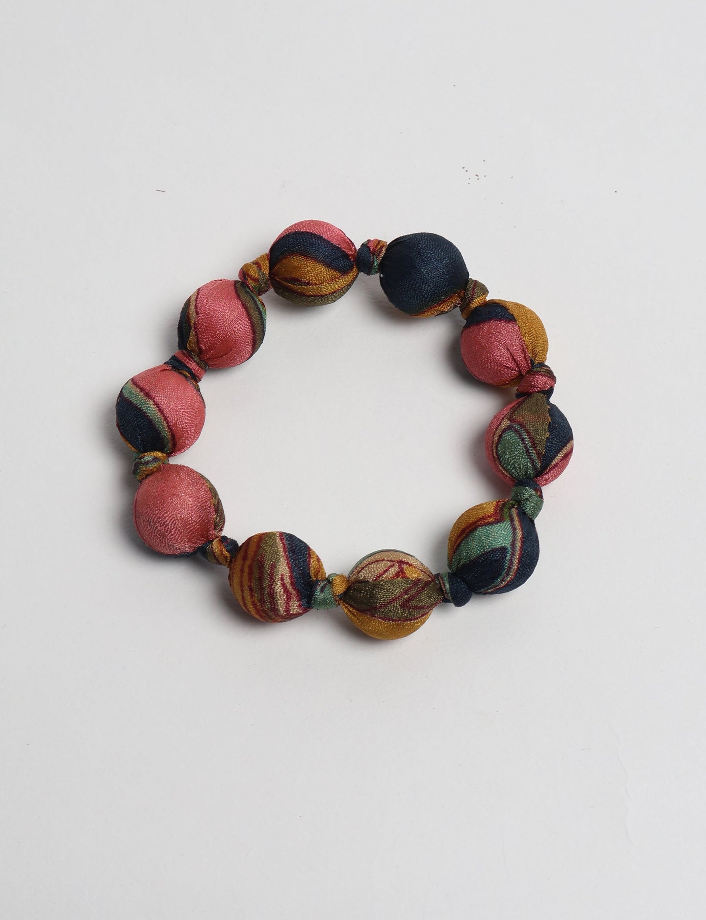 Eco friendly beaded knotted bracelet crafted from upcycled women’s clothing and repurposed sari fabrics, showcasing circular fashion and sustainable apparel.