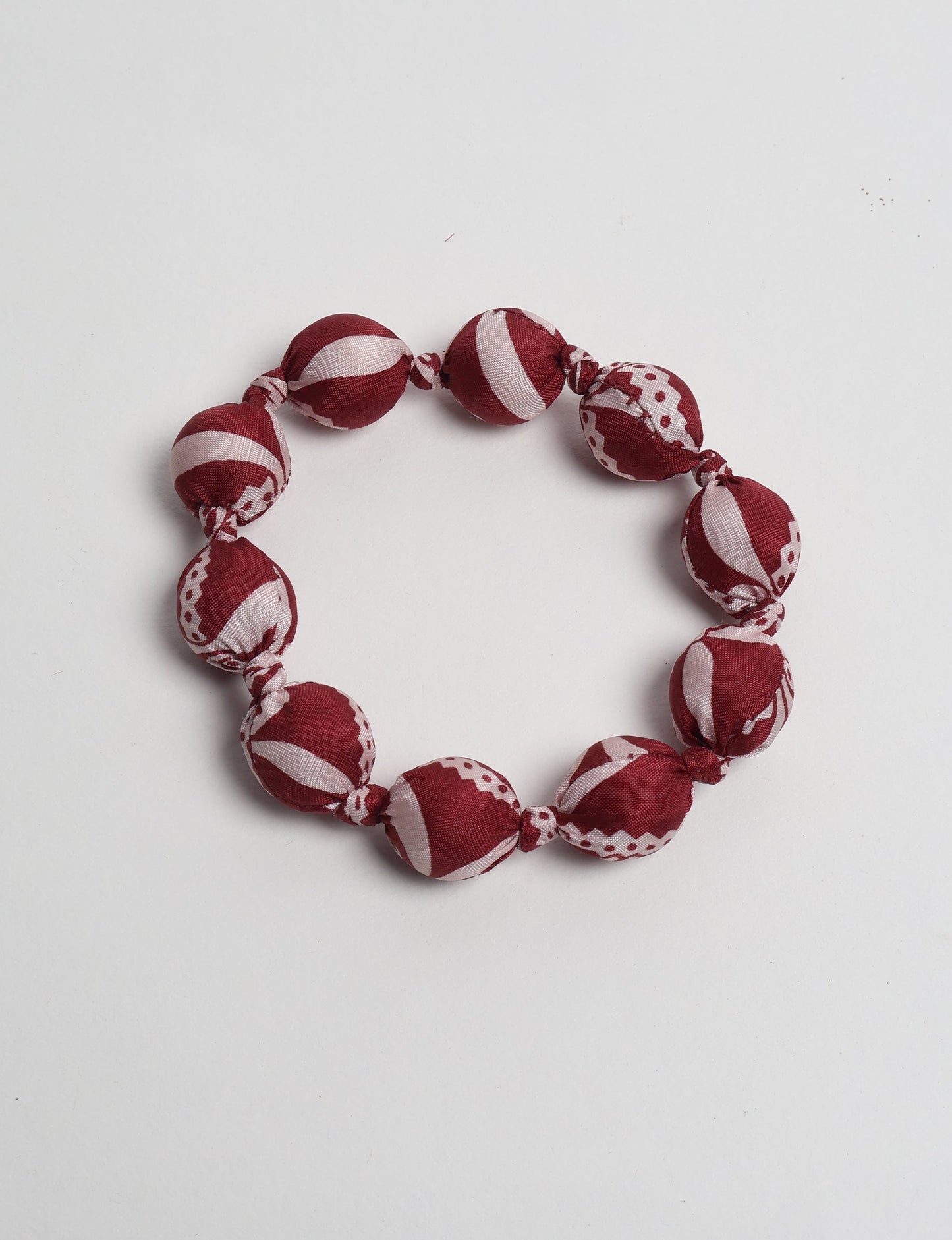 Eco friendly beaded knotted bracelet crafted from upcycled women’s clothing and repurposed sari fabrics, showcasing circular fashion and sustainable apparel.