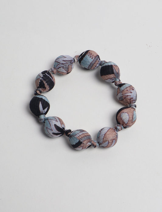 Eco friendly beaded knotted bracelet crafted from upcycled women’s clothing and repurposed sari fabrics, showcasing circular fashion and sustainable apparel.