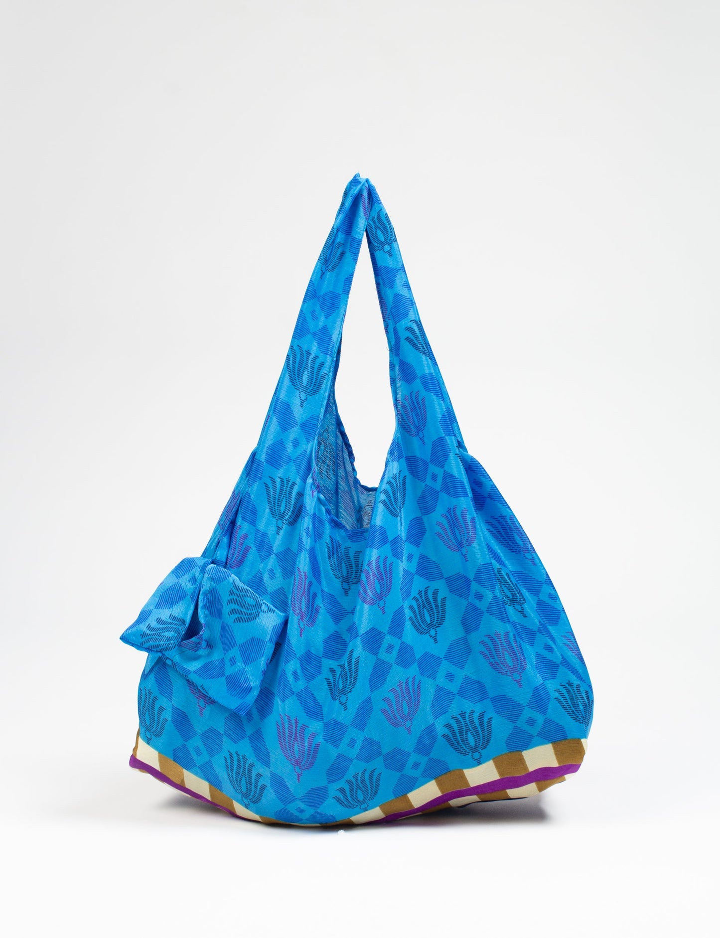 Stay eco-conscious with our Reusable Bag, handmade by Indian artisans from pre-loved saris. Silky and lightweight, this foldaway bag is perfect for your on-the-go lifestyle. Each piece is a unique statement of ethical fashion, embracing sustainability and style.