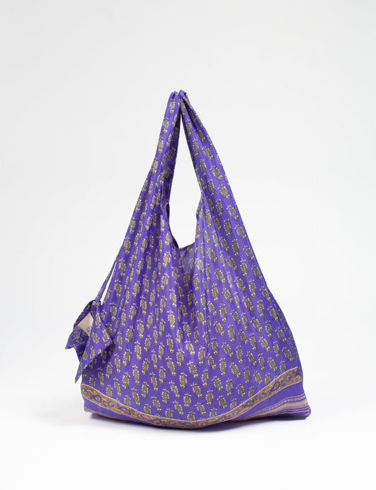 Stay eco-conscious with our Reusable Bag, handmade by Indian artisans from pre-loved saris. Silky and lightweight, this foldaway bag is perfect for your on-the-go lifestyle. Each piece is a unique statement of ethical fashion, embracing sustainability and style.