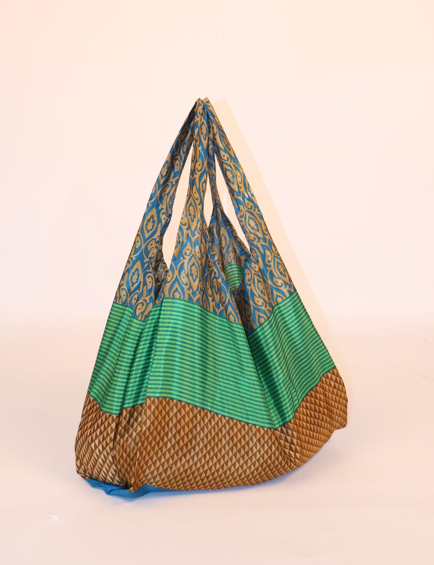 Stay eco-conscious with our Reusable Bag, handmade by Indian artisans from pre-loved saris. Silky and lightweight, this foldaway bag is perfect for your on-the-go lifestyle. Each piece is a unique statement of ethical fashion, embracing sustainability and style.