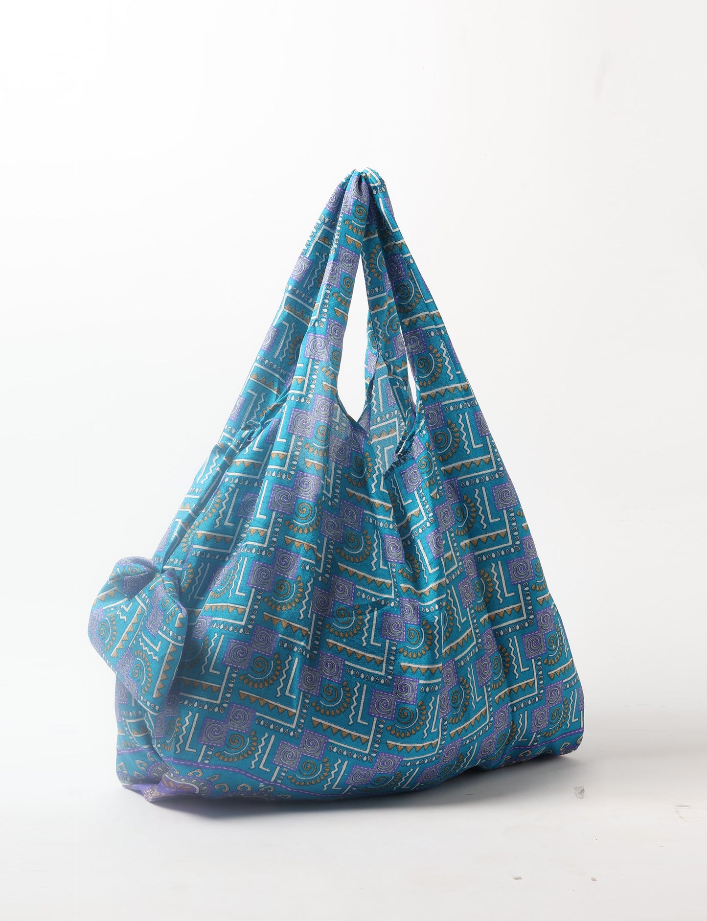 Stay eco-conscious with our Reusable Bag, handmade by Indian artisans from pre-loved saris. Silky and lightweight, this foldaway bag is perfect for your on-the-go lifestyle. Each piece is a unique statement of ethical fashion, embracing sustainability and style.