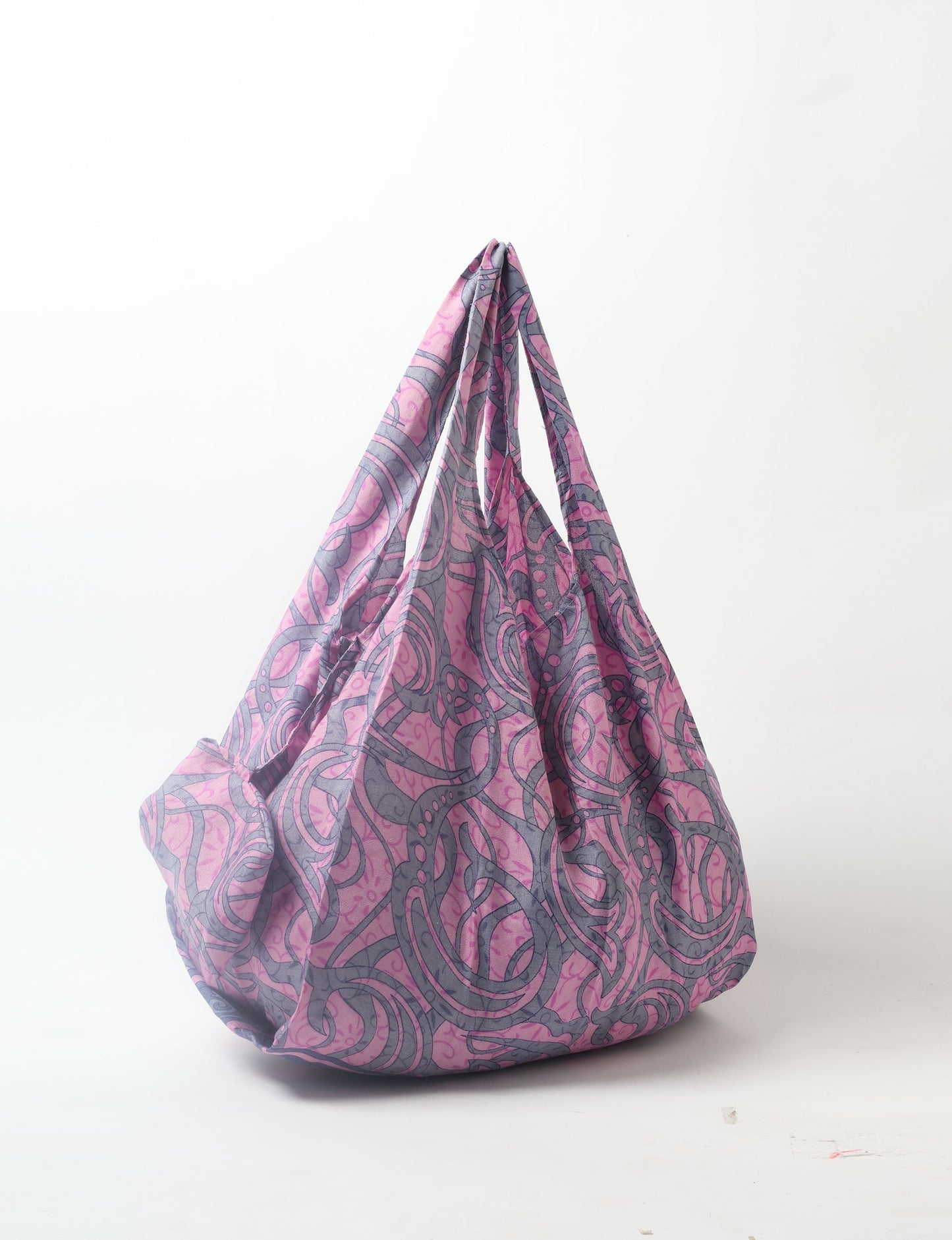 Stay eco-conscious with our Reusable Bag, handmade by Indian artisans from pre-loved saris. Silky and lightweight, this foldaway bag is perfect for your on-the-go lifestyle. Each piece is a unique statement of ethical fashion, embracing sustainability and style.