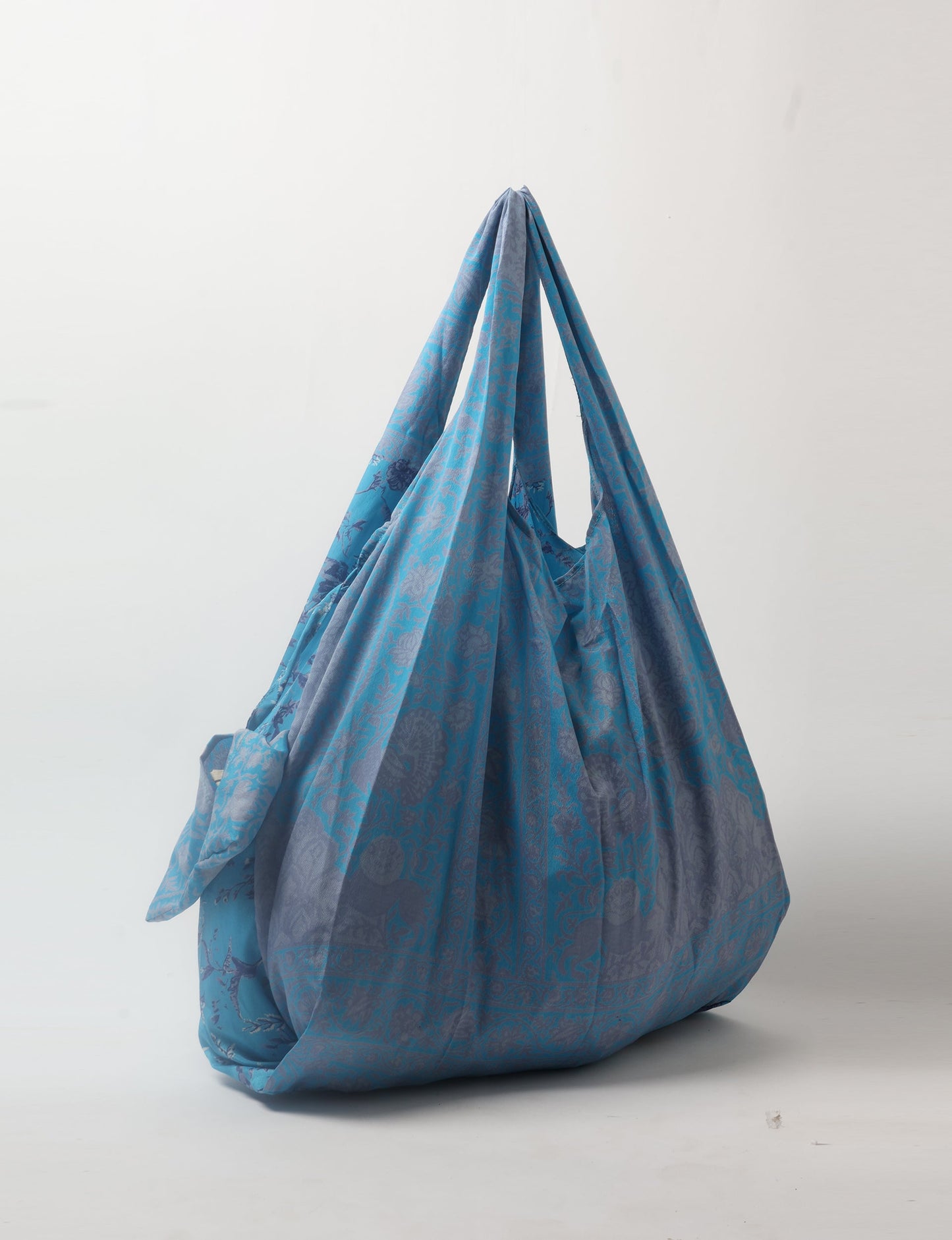 Stay eco-conscious with our Reusable Bag, handmade by Indian artisans from pre-loved saris. Silky and lightweight, this foldaway bag is perfect for your on-the-go lifestyle. Each piece is a unique statement of ethical fashion, embracing sustainability and style.