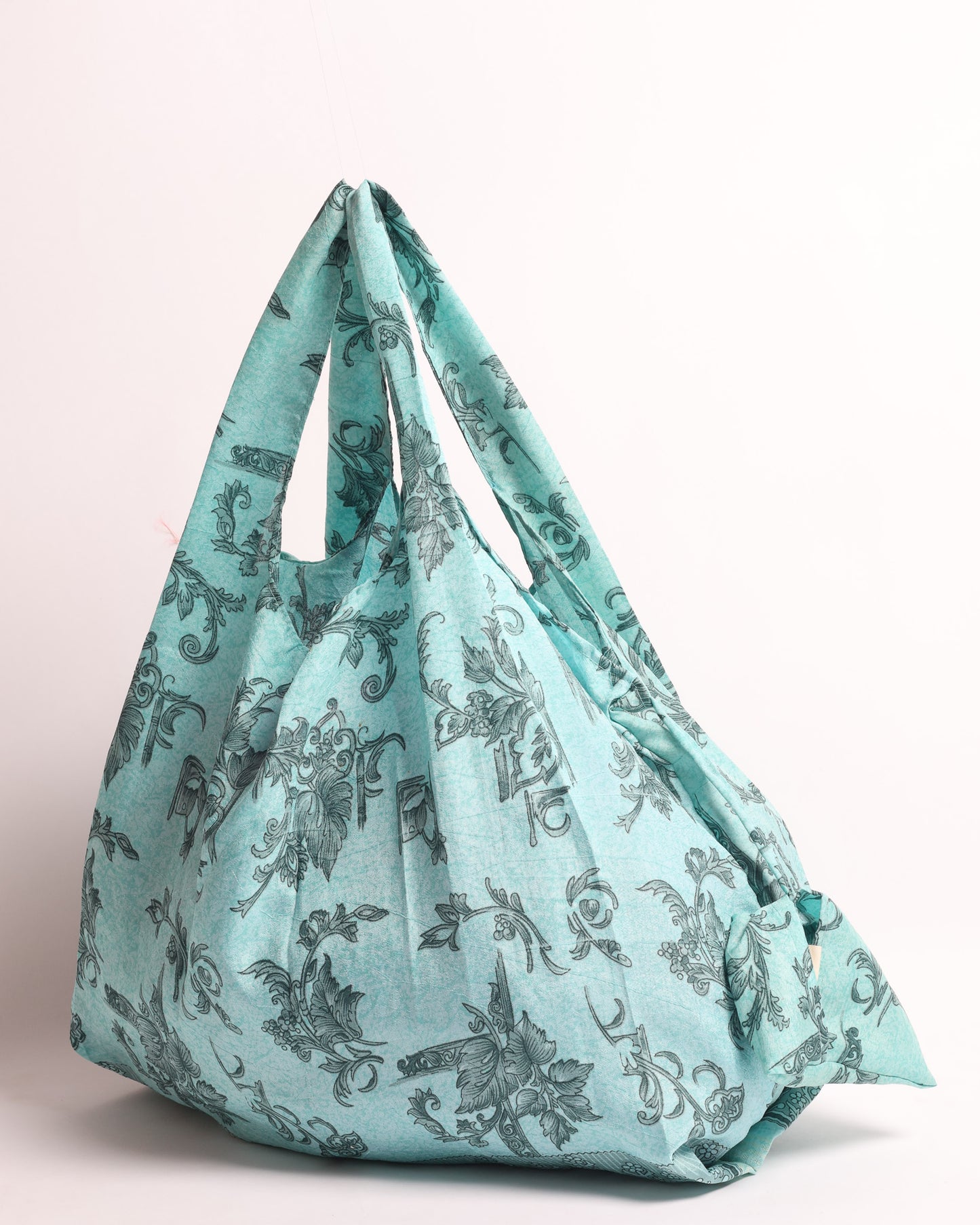 Stay eco-conscious with our Reusable Bag, handmade by Indian artisans from pre-loved saris. Silky and lightweight, this foldaway bag is perfect for your on-the-go lifestyle. Each piece is a unique statement of ethical fashion, embracing sustainability and style.