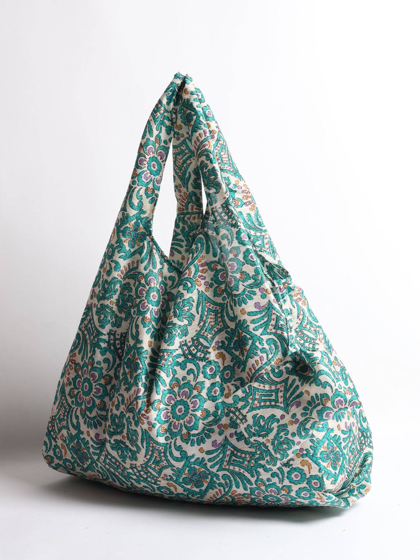 Stay eco-conscious with our Reusable Bag, handmade by Indian artisans from pre-loved saris. Silky and lightweight, this foldaway bag is perfect for your on-the-go lifestyle. Each piece is a unique statement of ethical fashion, embracing sustainability and style.