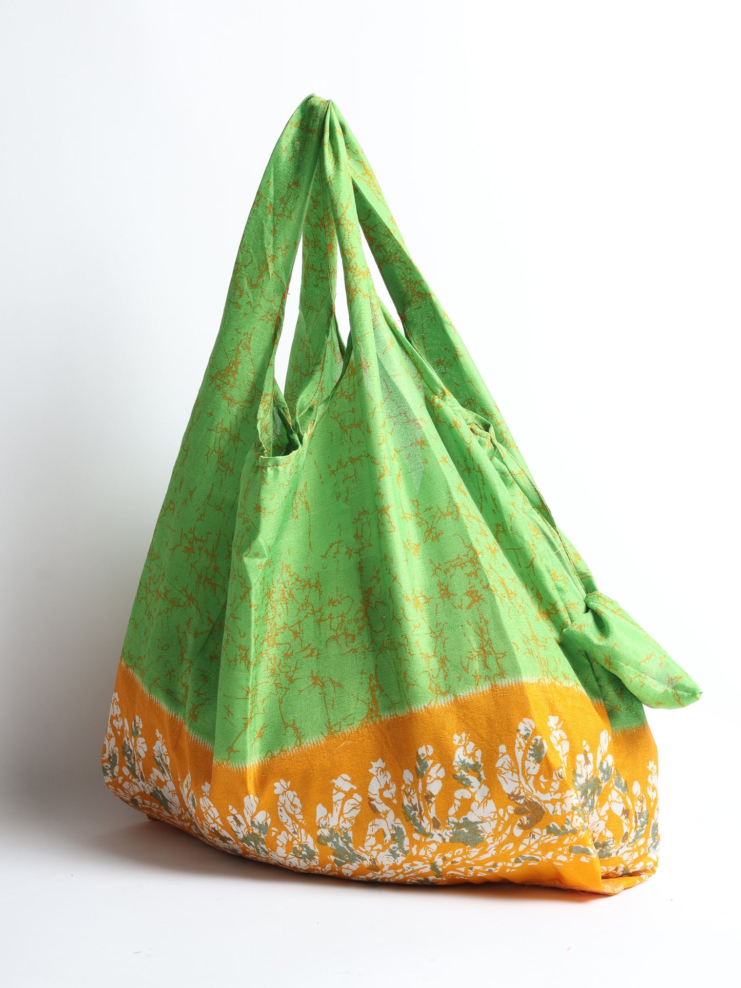 Stay eco-conscious with our Reusable Bag, handmade by Indian artisans from pre-loved saris. Silky and lightweight, this foldaway bag is perfect for your on-the-go lifestyle. Each piece is a unique statement of ethical fashion, embracing sustainability and style.